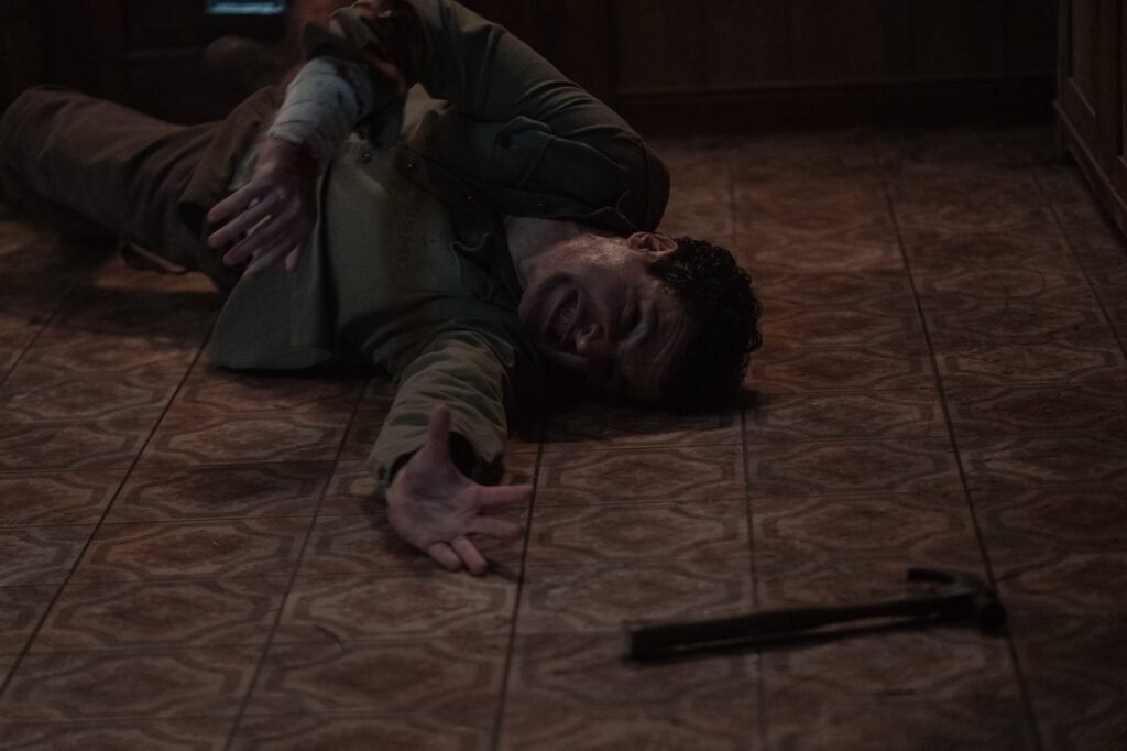 Blake on the floor reaching for a hammer.